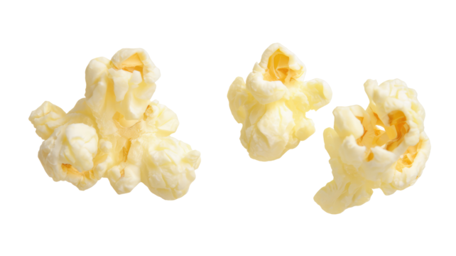 Three pieces of popped popcorn isolated on black background with buttery texture visible closely on transparent background