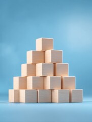Pyramid of wooden toy blocks on blue background studio shot close up education learning concept