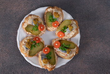Homemade sandwiches with salted herring, melted cheese, carrot and pickled cucumber