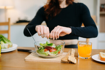 Young woman learning online cooking class via tablet computer in kitchen