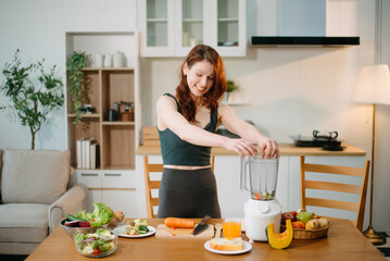 Fit woman enjoys fresh salad, fruits, and juice in a modern kitchen, showcasing wellness,...