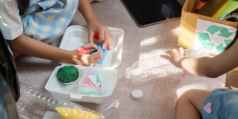 Creative Recycling and Sustainable Education. Children engaged in transforming used materials into...