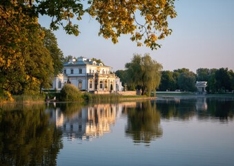 Fototapeta premium Elegant mansion by a tranquil lake at sunset.