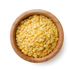 Raw lentils in a wooden plate on a white background. Top view