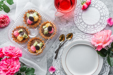 Set of mini basket cakes or sand tartlets cake with cream on light background with rose flowers....