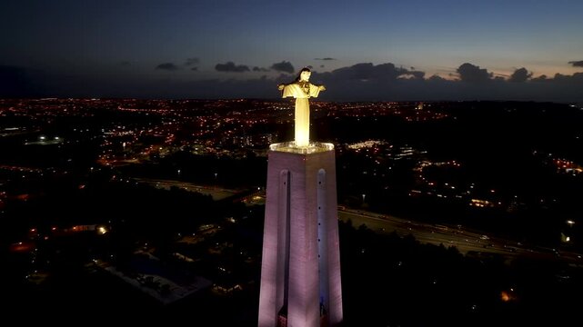 Night Scape Of Christ The King At Lisbon In Lisbon District Portugal. Illuminated King Christ. 25 Of April Bridge. Christ The King At Lisbon In Portugal. Tejo River Coast. Landmark Sanctuary.