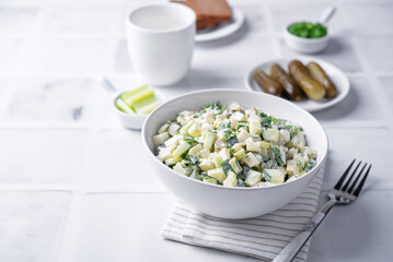 Cucumber egg mayonnaise salad in a bowl on a white background