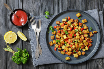 golden fried potatoes cubes with red bell pepper