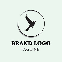 Fototapeta premium Black bird silhouette in flight within a circle logo design. Simple, minimalist design with a brand logo and tagline area for a business or organization.