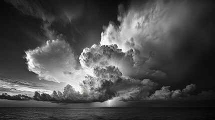 A dramatic black-and-white image of a stormy sky filled with dense, swirling clouds.