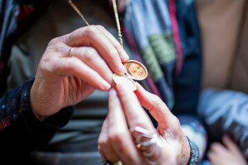 Grandmother opens golden locket revealing grandchild's photo inside