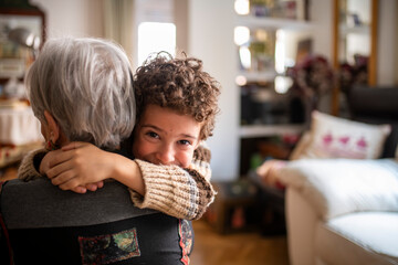 Grandchild hugging grandmother at home showing love and affection