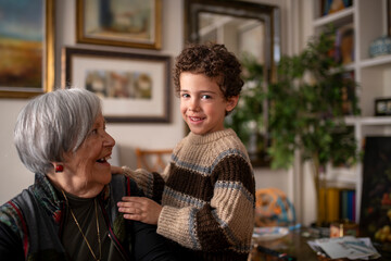 Grandson hugging grandmother at home showing love and affection