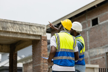 Reviewing blueprints, Two African American engineer wearing safety gear at construction site, copy space. engineering, architect, planning, development, teamwork site house
