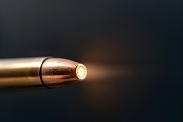 Close-up View of a Bullet Tip Illuminated Against a Dark Background Highlighting Detail and Precision