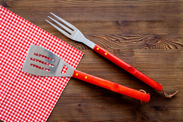 Set with barbecue utensils and equipment with red picnic napkin. Stainless steel tools. Top view