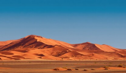 Naklejka premium Vast expanse of orange dunes under a clear blue sky