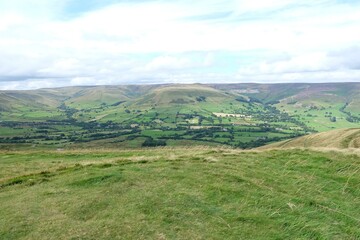 Obraz premium a person sitting on a hill looking out over the countryside