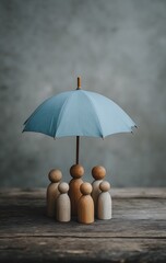 Wooden figures under a blue umbrella symbolize family protection and insurance security