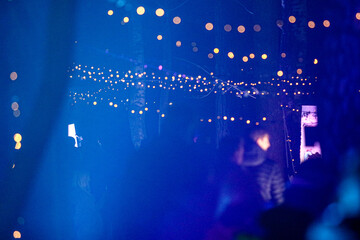 Night Scene with People Under Festive String Lights in Blue Atmospheric Lighting