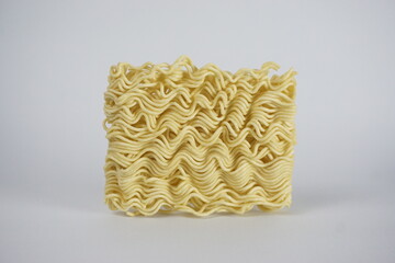 Noodle Block: A close-up shot showcases a dry, uncooked block of instant noodles, with an appetizing texture.