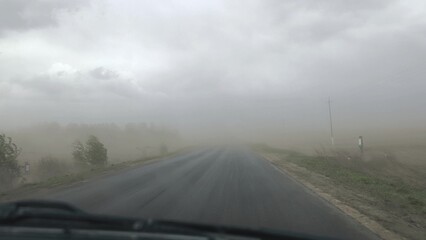 Driving in the rain. fog over the road, sandstorm on the way, strong wind, extreme weather conditions on the highway.