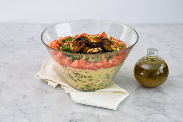 Mediterranean Couscous Salad with Grilled Eggplant on napkin featuring fluffy couscous, tomatoes,...