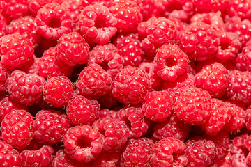 Fresh raspberries, showcasing their vibrant red color and textured surfaces. Macro shot of...