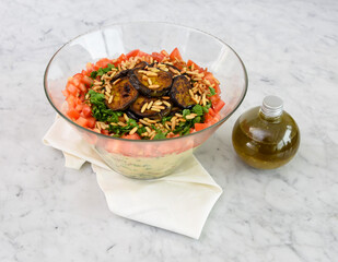 Mediterranean Couscous Salad with Grilled Eggplant on napkin featuring fluffy couscous, tomatoes,...