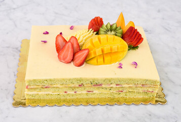 Elegant Pistachio Layer Cake with Tropical Fruit including strawberries, mango, kiwi, and...