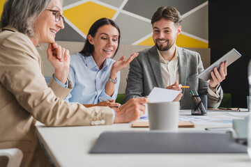 Team of professionals having a meeting in a digital marketing agency. Business people discussing a project in an office. Teamwork and collaboration in a creative workplace.