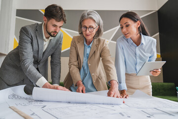In Architectural Bureau: Team of Architects and Engineers Working on a Building Complex Prototype Project, Using City Model and Computers Running 3D CAD Software. Residential or Business District
