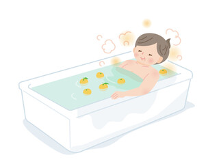 柚子風呂に入ってのんびりする中年女性