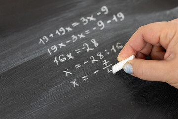 Close-up Shot of a Hand Holding Chalk and Writing Equation on the Blackboard.
