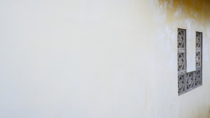 Building walls with geometric patterned air vents made of concrete. The yellowish color of the walls with a worn-out wall texture gives a vintage and classic impression.