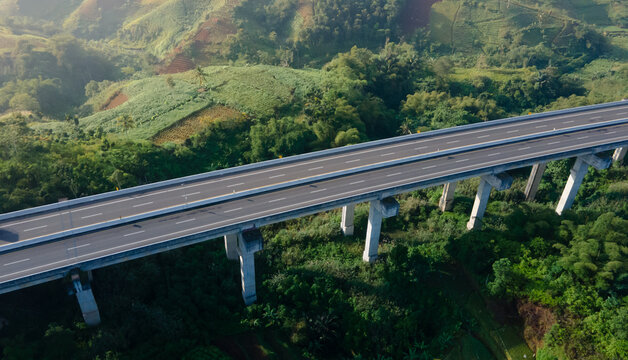 Empty Elevated Toll Road Bridge Over Lush Green Hills