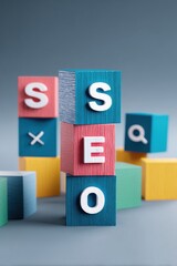 Colorful building blocks arranged to spell out SEO against a gradient background with additional blocks scattered around
