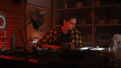 Young Man Examining Photographic Film in Cozy Studio