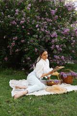 Woman Reads Book During Springtime Picnic Outdoors