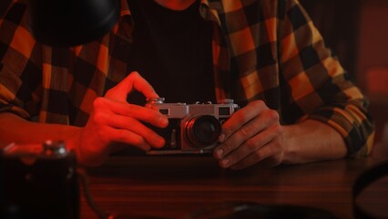 Hands Holding Vintage Camera in Artistic Red Lighting