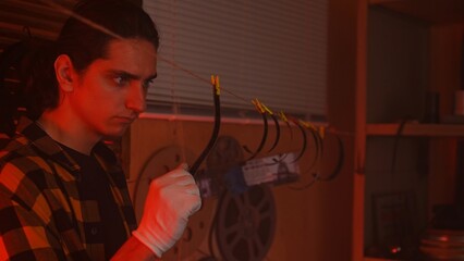 Person Working Intently in a Darkroom with Film Reels