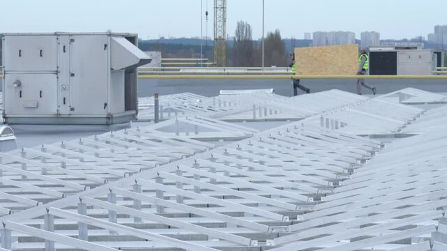 A frame and trusses for attaching solar panels are installed on the roof of the building.