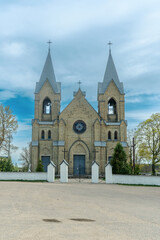 The image of St. Anne's Neo-Gothic Church in Rakow, Belarus, showcases spring's beauty with its Gothic and Classicism elements, adorned with Catholic crosses, symbolizing faith and heritage.
