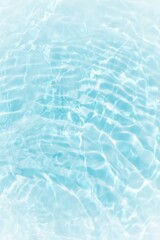 Blue water with ripples on the surface. Defocus blurred transparent blue colored clear calm water surface texture with splashes and bubbles. Water waves with shining pattern texture background.