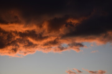 Dramatic sunset with vibrant orange clouds against dark sky