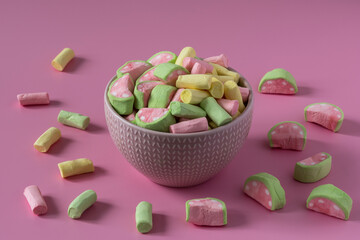Colored marshmallow with watermelon flavor in a porcelain bowl on a pink background, side view, copy space , high-resolution .