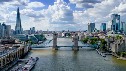 Aerial hyper time lapse day view of the lifted open Tower Bridge and city skyline of London, England, with river and people traffic