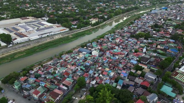 Aerial overview of dilapidated rooftops and polluted river along Marikina City, Luzon, Philippines.