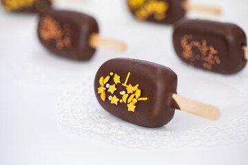 chocolate ice cream on a stick isolated on a white background. Chocolate Popsicles with Gold Sprinkles
