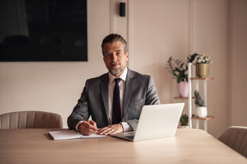 Obraz premium Confident Businessman Working at Desk in Modern Office Environment